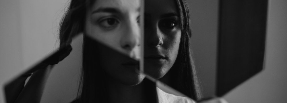 black and white image of woman staring off into reflection
